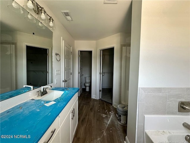 bathroom featuring vanity, an enclosed shower, hardwood / wood-style flooring, and toilet