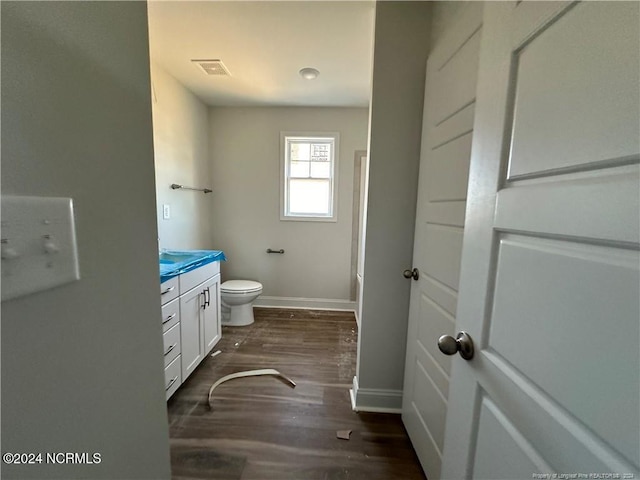 bathroom with toilet, hardwood / wood-style floors, and vanity