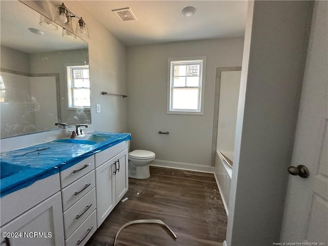 full bathroom featuring vanity, hardwood / wood-style floors, toilet, and plenty of natural light