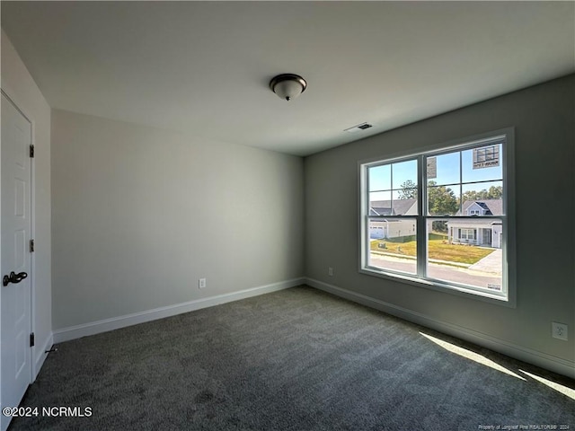 spare room with dark carpet