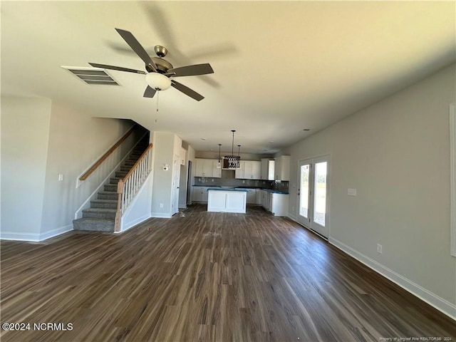 unfurnished living room featuring ceiling fan and dark hardwood / wood-style flooring