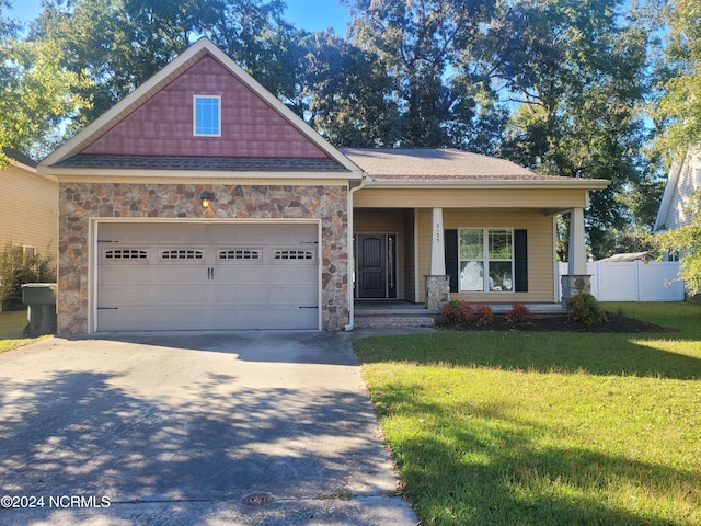 craftsman house featuring a front yard and a garage