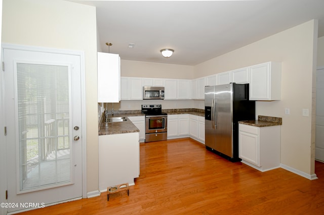 kitchen featuring light hardwood / wood-style floors, white cabinets, stainless steel appliances, and sink