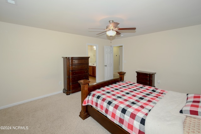 carpeted bedroom with ensuite bathroom and ceiling fan