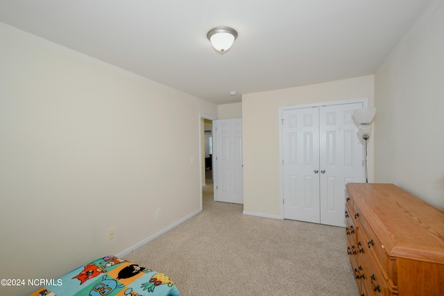 unfurnished bedroom with a closet and light colored carpet