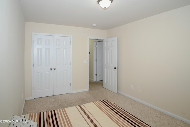 unfurnished bedroom with a closet and light carpet