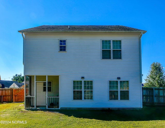 rear view of property featuring a lawn