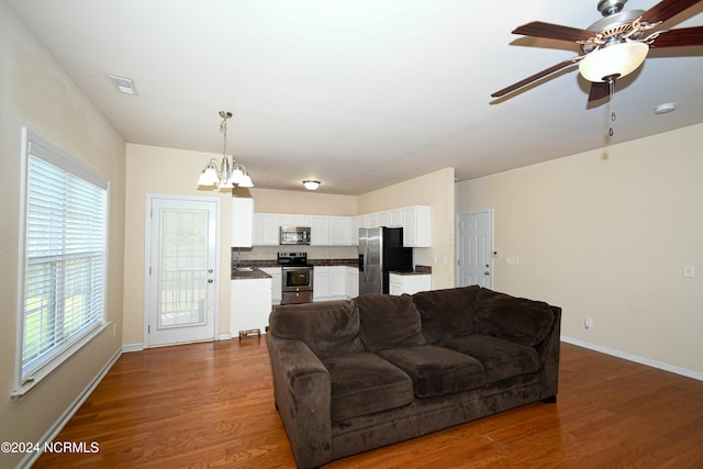 living room with wood-type flooring, plenty of natural light, and ceiling fan with notable chandelier