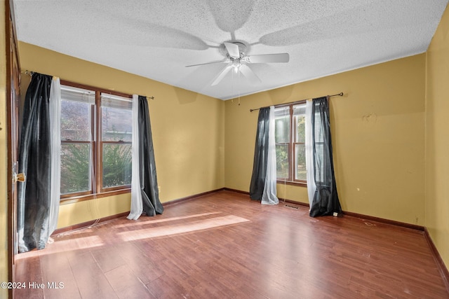 unfurnished room with a textured ceiling, hardwood / wood-style flooring, and ceiling fan