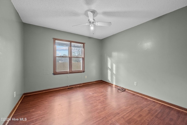 empty room featuring hardwood / wood-style floors, a textured ceiling, and ceiling fan