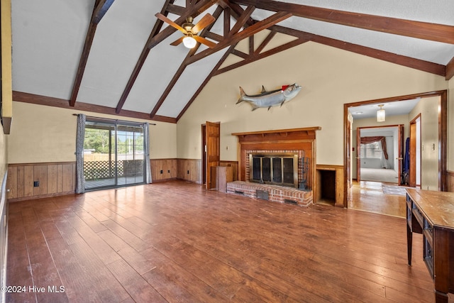 unfurnished living room with wood-type flooring, high vaulted ceiling, beamed ceiling, ceiling fan, and a fireplace