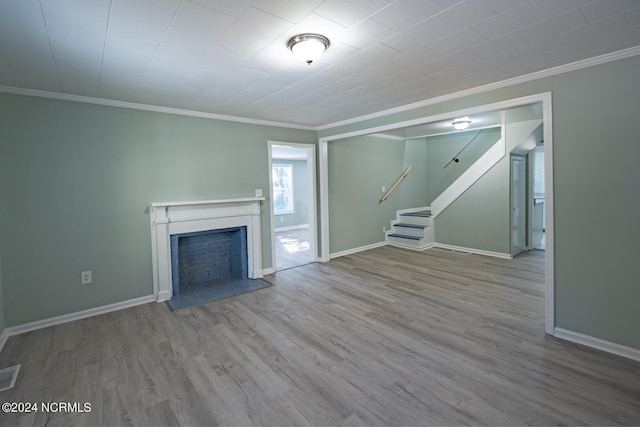 unfurnished living room with ornamental molding and light hardwood / wood-style flooring