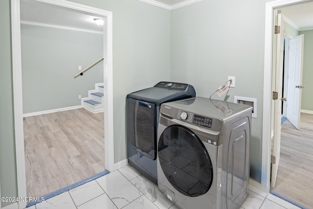 laundry room with ornamental molding, washer and clothes dryer, and light wood-type flooring