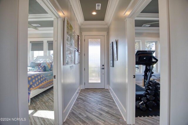 living room featuring crown molding, hardwood / wood-style floors, wooden walls, and ceiling fan