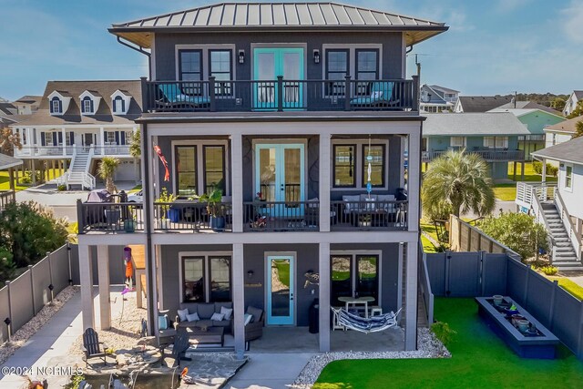 back of house with a swimming pool, a patio area, a yard, and a balcony