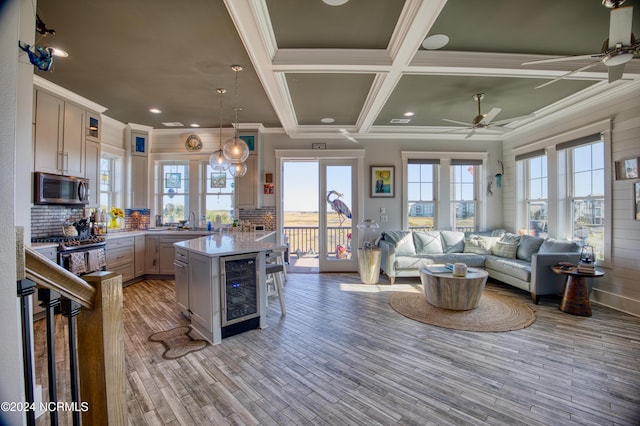 kitchen featuring hanging light fixtures, a breakfast bar area, stainless steel appliances, a kitchen island, and wine cooler