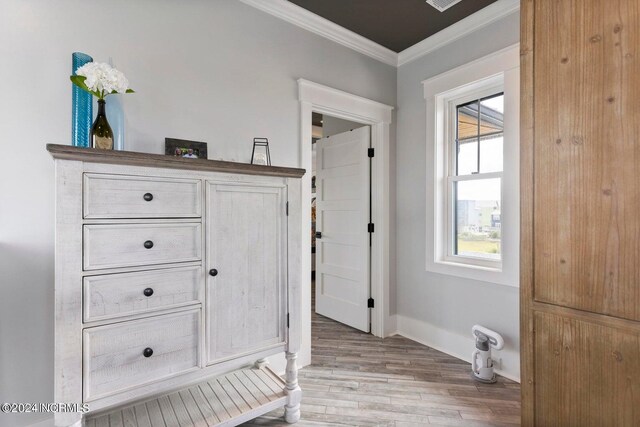 interior space featuring elevator, light wood-type flooring, and crown molding