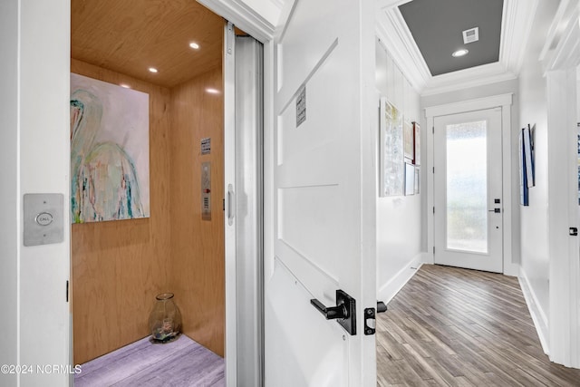 interior space featuring light wood-type flooring, elevator, and ornamental molding