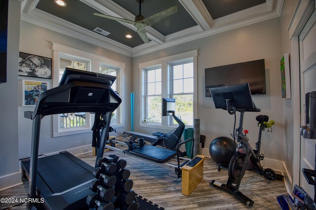 workout area featuring ceiling fan, light wood-type flooring, crown molding, and coffered ceiling