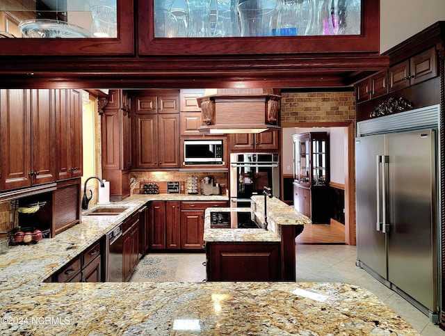 kitchen with light tile patterned floors, light stone countertops, sink, and black appliances