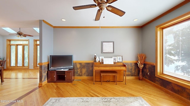 office space featuring ornamental molding, a wealth of natural light, light hardwood / wood-style floors, and a skylight