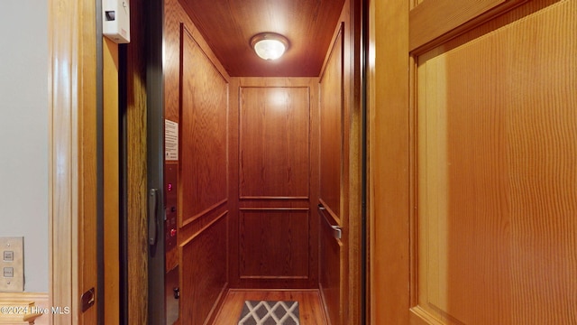 room details featuring elevator and wood walls