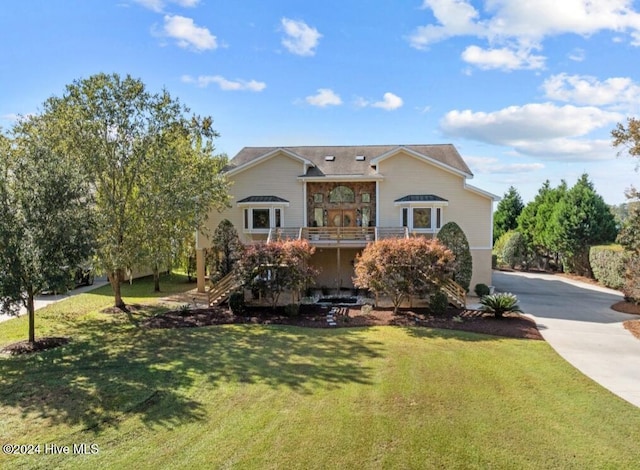 view of front of home featuring a front yard and a balcony