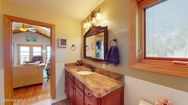 bathroom with tile patterned flooring, vaulted ceiling, plenty of natural light, and vanity