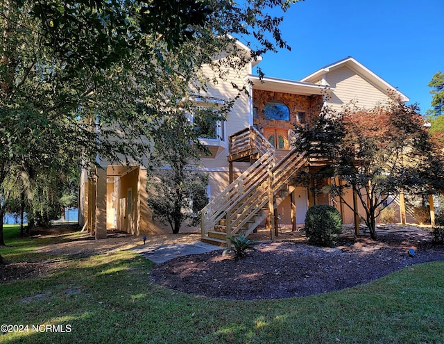 back of property featuring a wooden deck and a yard