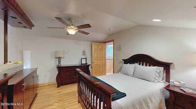 bedroom with ceiling fan, light hardwood / wood-style floors, and vaulted ceiling