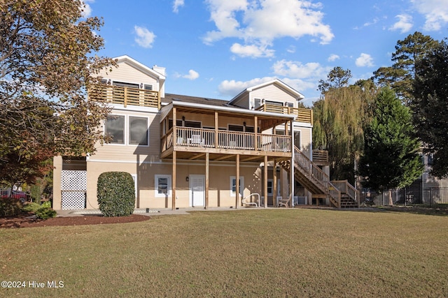 rear view of house with a wooden deck and a lawn