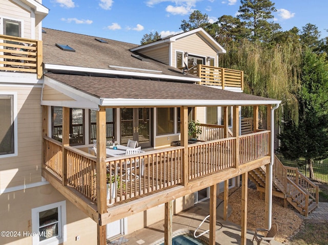 rear view of property featuring a wooden deck