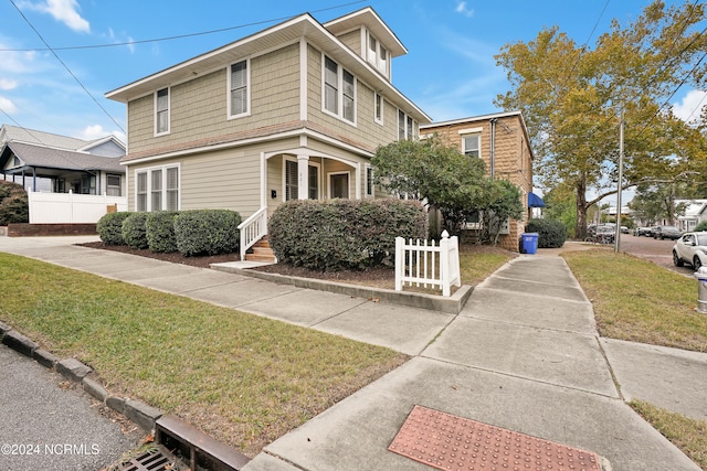 view of front of house with a front yard and a porch