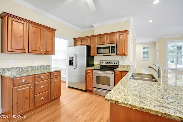 kitchen with ceiling fan, appliances with stainless steel finishes, light wood-type flooring, crown molding, and sink