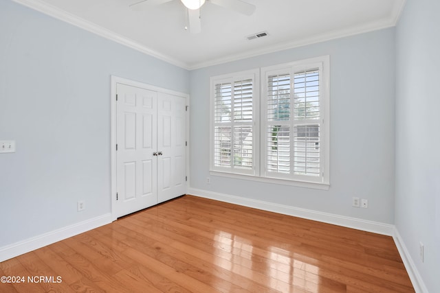 empty room featuring ceiling fan, ornamental molding, and light wood-type flooring