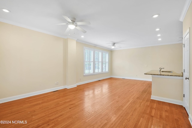 unfurnished living room with ornamental molding, sink, light hardwood / wood-style floors, and ceiling fan