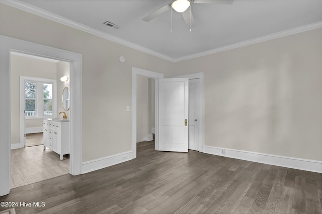 unfurnished bedroom with ensuite bathroom, ornamental molding, ceiling fan, sink, and dark hardwood / wood-style floors