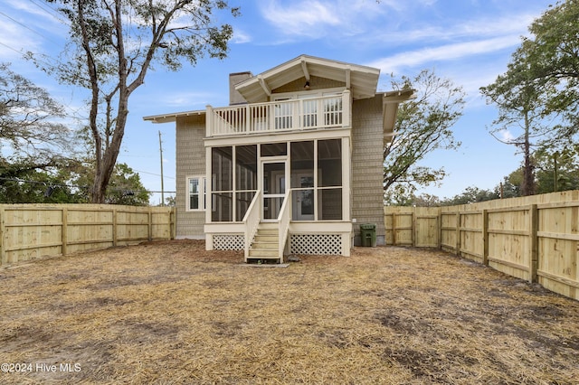 back of house featuring a sunroom and a balcony