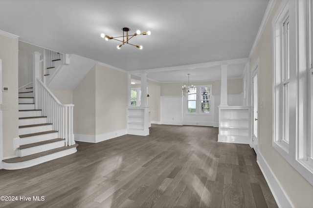 unfurnished living room featuring a chandelier, dark hardwood / wood-style flooring, decorative columns, and ornamental molding