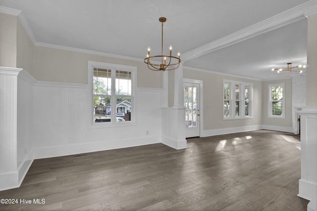 unfurnished dining area with dark hardwood / wood-style floors, an inviting chandelier, and ornamental molding