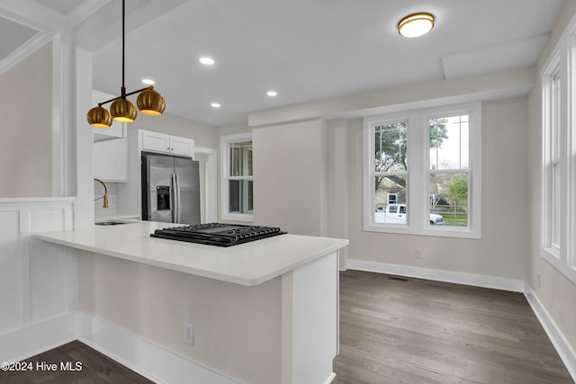 kitchen with white cabinets, pendant lighting, dark hardwood / wood-style floors, and appliances with stainless steel finishes