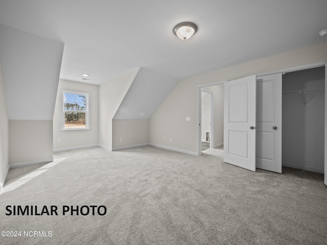 additional living space featuring light carpet and lofted ceiling