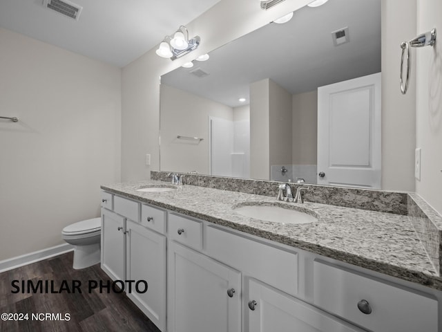 bathroom featuring vanity, hardwood / wood-style flooring, and toilet