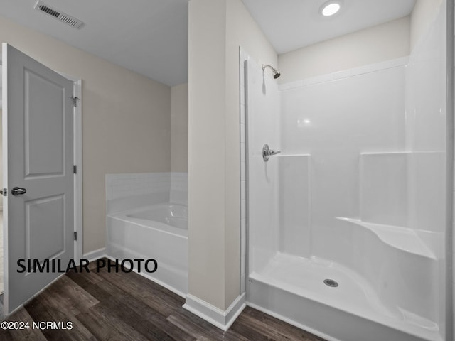 bathroom with independent shower and bath and hardwood / wood-style floors