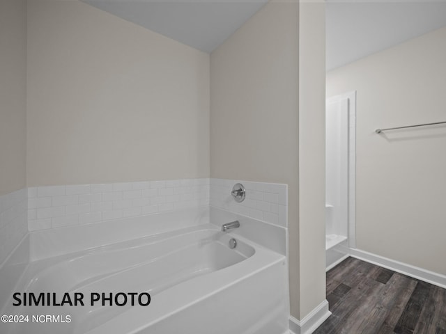 bathroom with wood-type flooring and a washtub