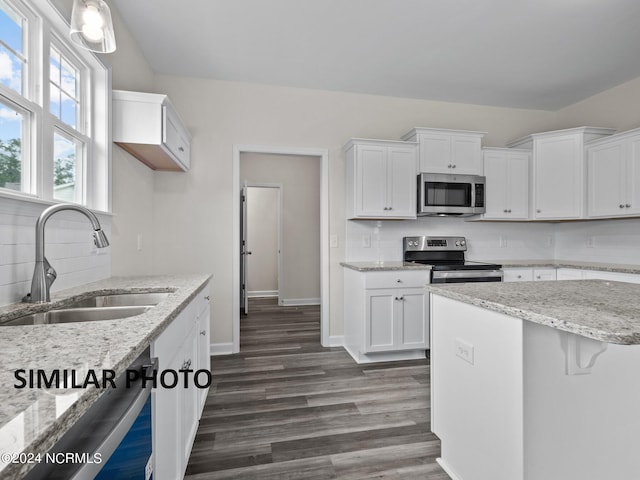 kitchen with white cabinetry, stainless steel appliances, sink, and backsplash