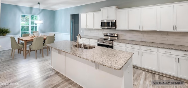 kitchen featuring decorative backsplash, appliances with stainless steel finishes, pendant lighting, and white cabinets