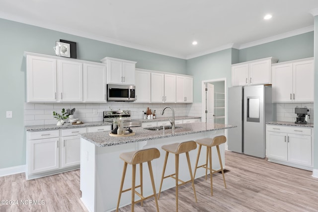 kitchen with light hardwood / wood-style flooring, stainless steel appliances, sink, and white cabinets