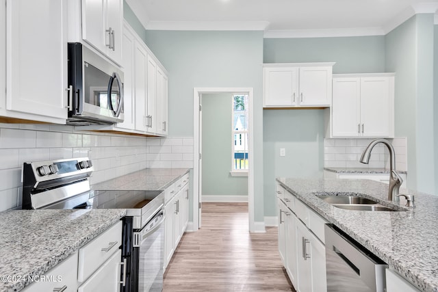 kitchen featuring light stone countertops, sink, appliances with stainless steel finishes, and white cabinets