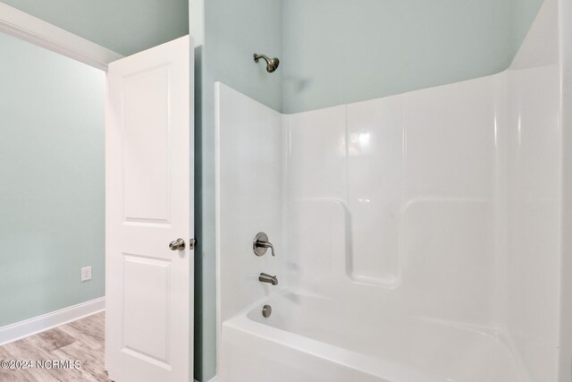 bathroom featuring wood-type flooring and shower / washtub combination